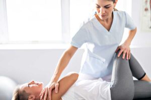 Person resting at home with a warm compress on the lower back after a chiropractic adjustment.